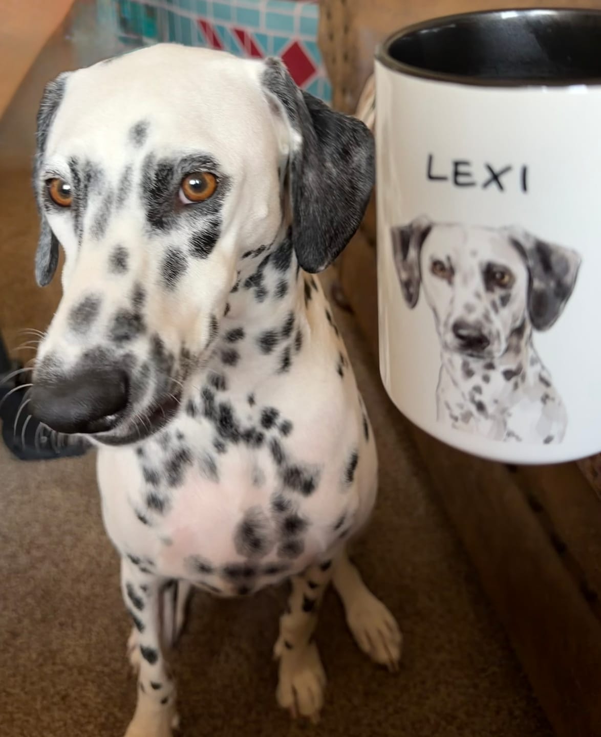 Dalmatian named Lexi next to a black-handled mug with her portrait